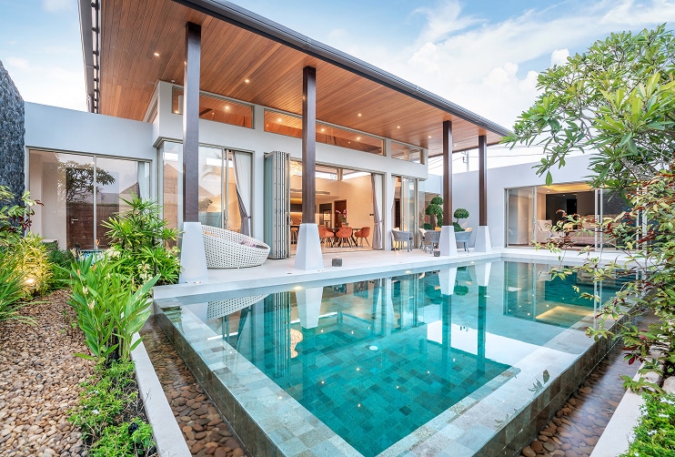 Modern home eligible for Costa Rica home loans mortgage financing, featuring a private pool, tropical landscaping, and open concept living space