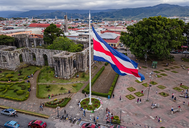 Costa Rican flag flying in front of historic ruins in Cartago, a cultural landmark near regions where U.S. buyers often explore costa rica mortgage options