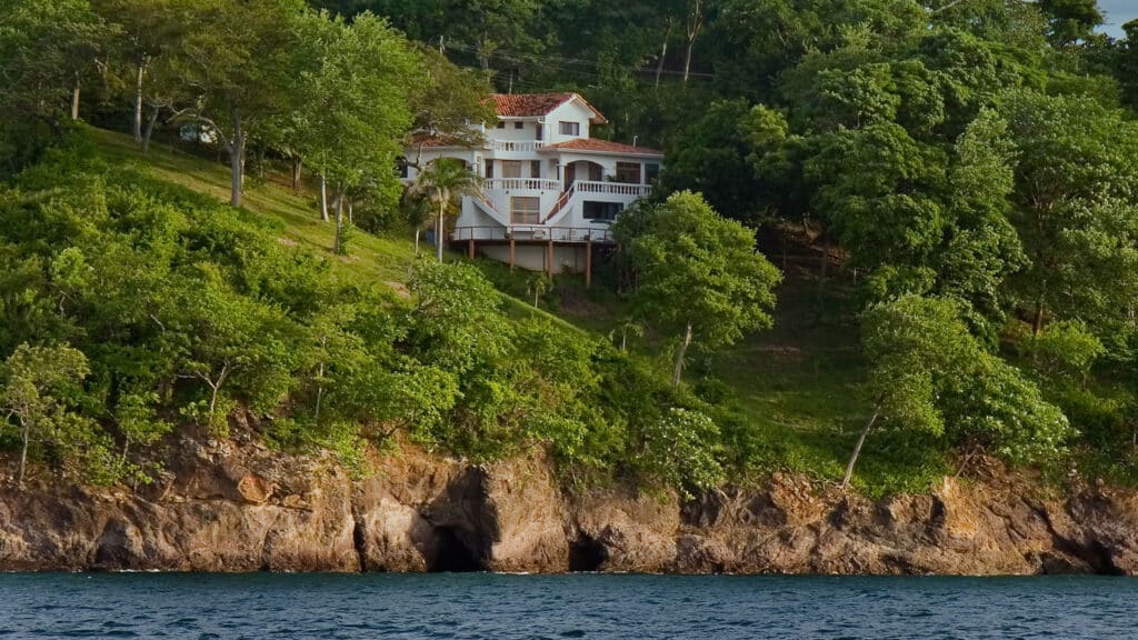 Oceanfront hillside home surrounded by lush trees in Costa Rica