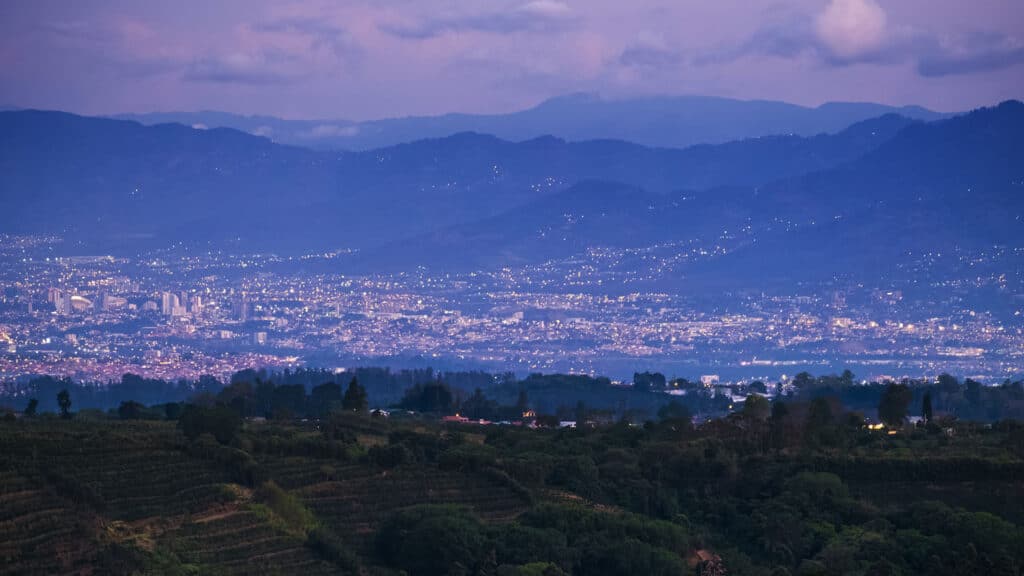 San Jose city lights spread across the Central Valley at dusk with mountains in the background