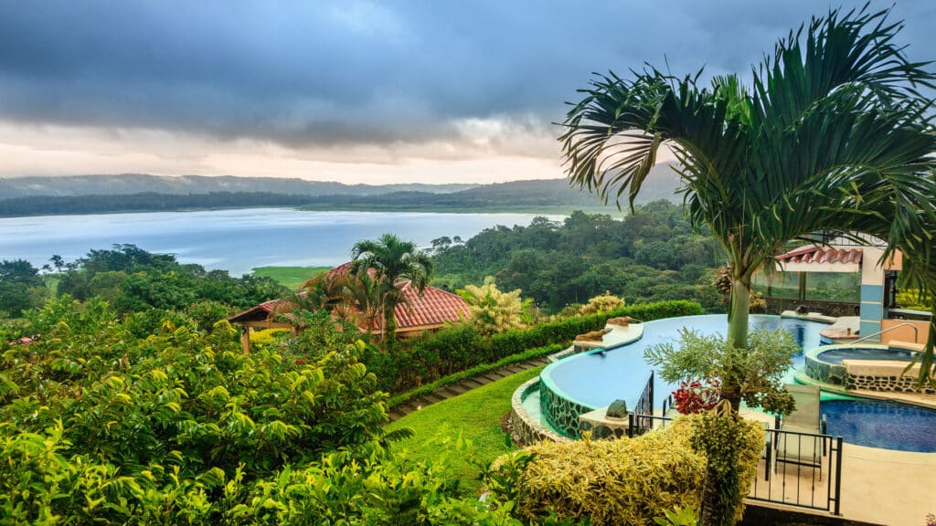 Hillside villa with infinity pool and tropical gardens overlooking Lake Arenal, a prime example of investment property in Costa Rica